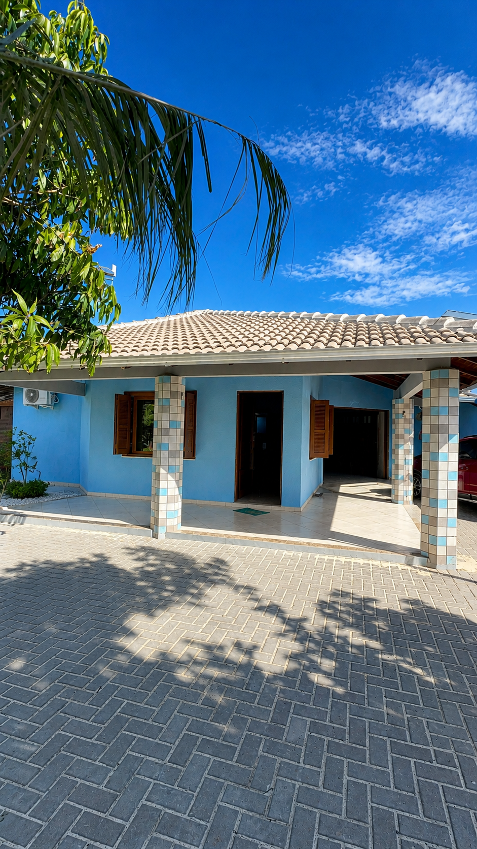 Casa azul com varanda e colunas revestidas